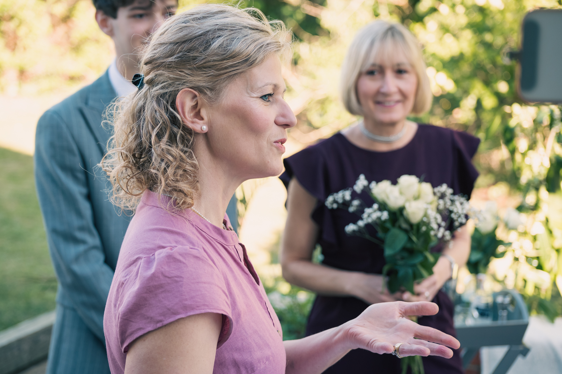 Samantha leading a garden ceremony as guests look on